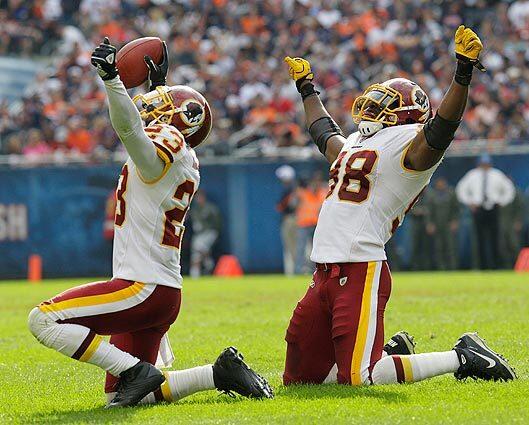 Washington Redskins cornerback DeAngelo Hall (23) celebrates with Brian Orakpo (98) after Hall intercepted a Chicago Bears pass in the second half of a football game in Chicago. The Redskins, won 17-14. Hall tied an NFL record with four interceptions in the game.