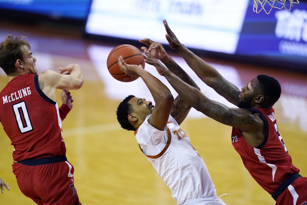 Texas forward Royce Hamm Jr. is pressured by Texas Tech guard Jamarius Burton and guard Mac McClung.