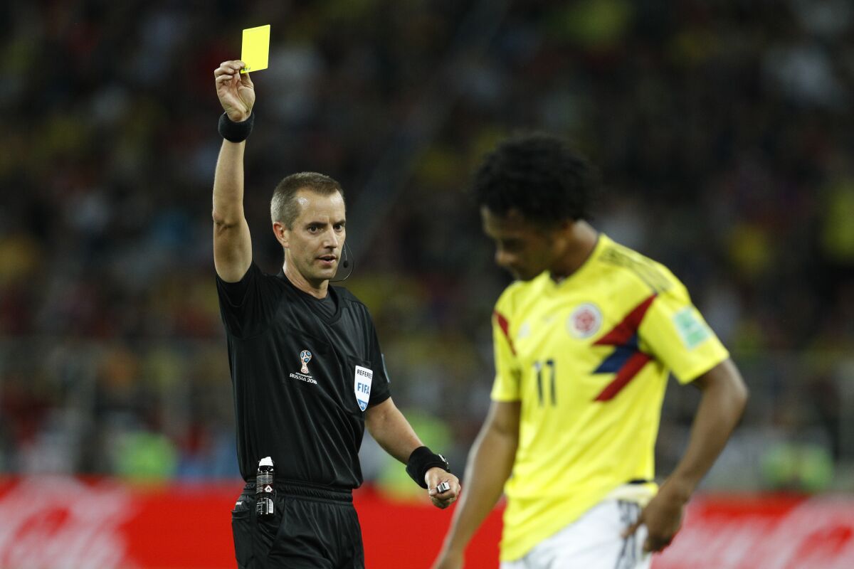 FILE - Referee Mark Geiger from the US shows a yellow card to Colombia's Juan Cuadrado during the round of 16 match between Colombia and England at the 2018 soccer World Cup in the Spartak Stadium, in Moscow, Russia, Tuesday, July 3, 2018. Geiger will take over from Howard Webb as the head of referees in Major League Soccer. The 48-year-old Geiger, who retired as a referee after the 2018 season, was promoted Friday, Feb. 3, 2023 to general manager of the Professional Referee Organization that supplies MLS match officials. (AP Photo/Victor R. Caivano, File)