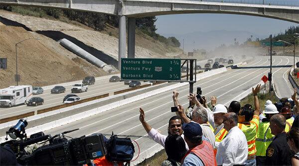 L.A. Mayor Villaraigosa and City Councilman Tom LaBonge join officials and media as they wave to the first motorists to travel under the Mulholland Drive bridge after the reopening of the 405 Freeway.