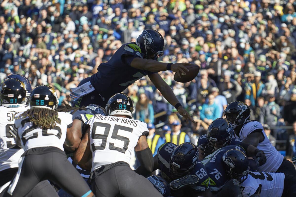 Seattle Seahawks quarterback Geno Smith leaps over the line to score a touchdown against the Jacksonville Jaguars.