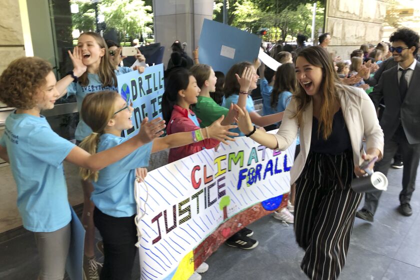FILE - Kelsey Juliana, of Eugene, Ore., a lead plaintiff who is part of a lawsuit by a group of young people who say U.S. energy policies are causing climate change and hurting their future, greets supporters outside a federal courthouse, June 4, 2019, in Portland, Ore. A federal judge ruled on Thursday, June 1, 2023, that a lawsuit brought by young Oregon-based climate activists can proceed to trial years after they first filed the lawsuit in an attempt to hold the nation’s leadership accountable for its role in climate change. (AP Photo/Andrew Selsky, File)