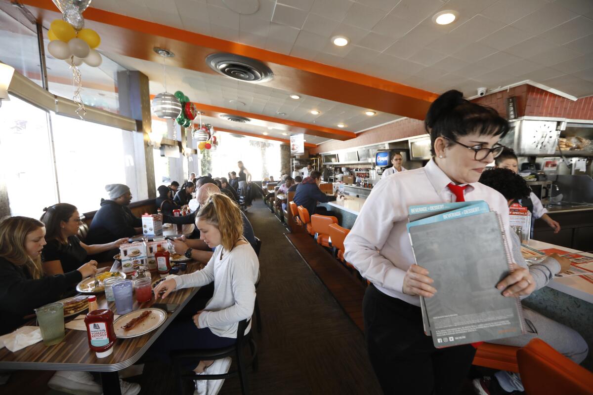 Hostess Hope Voedisch moves swiftly to greet customers.