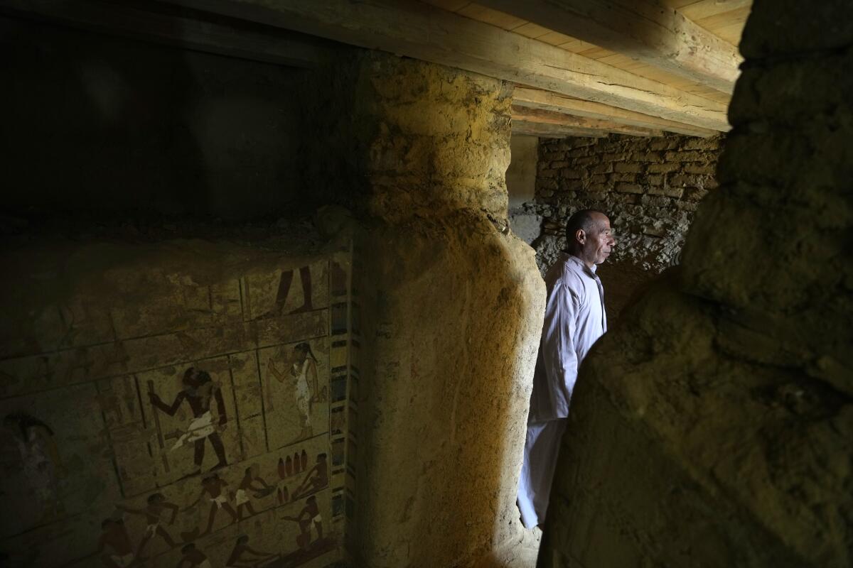 A man stands in an archaeological dig with Egyptian hieroglyphics 