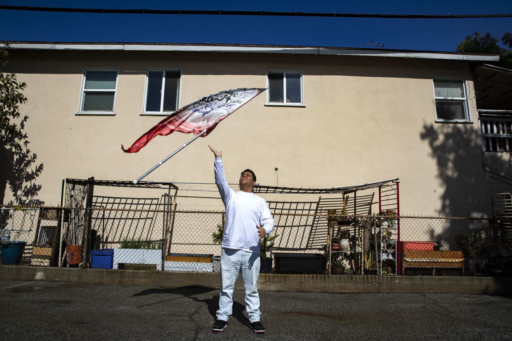 Alhambra High School senior Lucas Lozano tosses a flag into the air