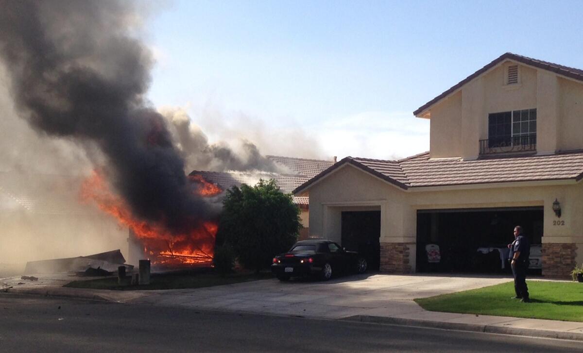 Flames and smoke billow from a civilian's house after a Marine jet crashed in Imperial, Calif. on Wednesday.
