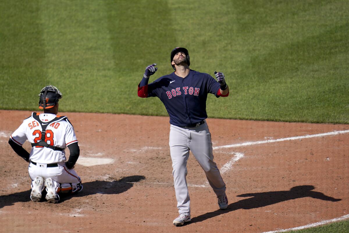 Boston Red Sox's J.D. Martinez reacts after hitting a solo home run off Baltimore Orioles starting pitcher Tyler Wells during the eighth inning of a baseball game, Sunday, April 11, 2021, in Baltimore. (AP Photo/Julio Cortez)