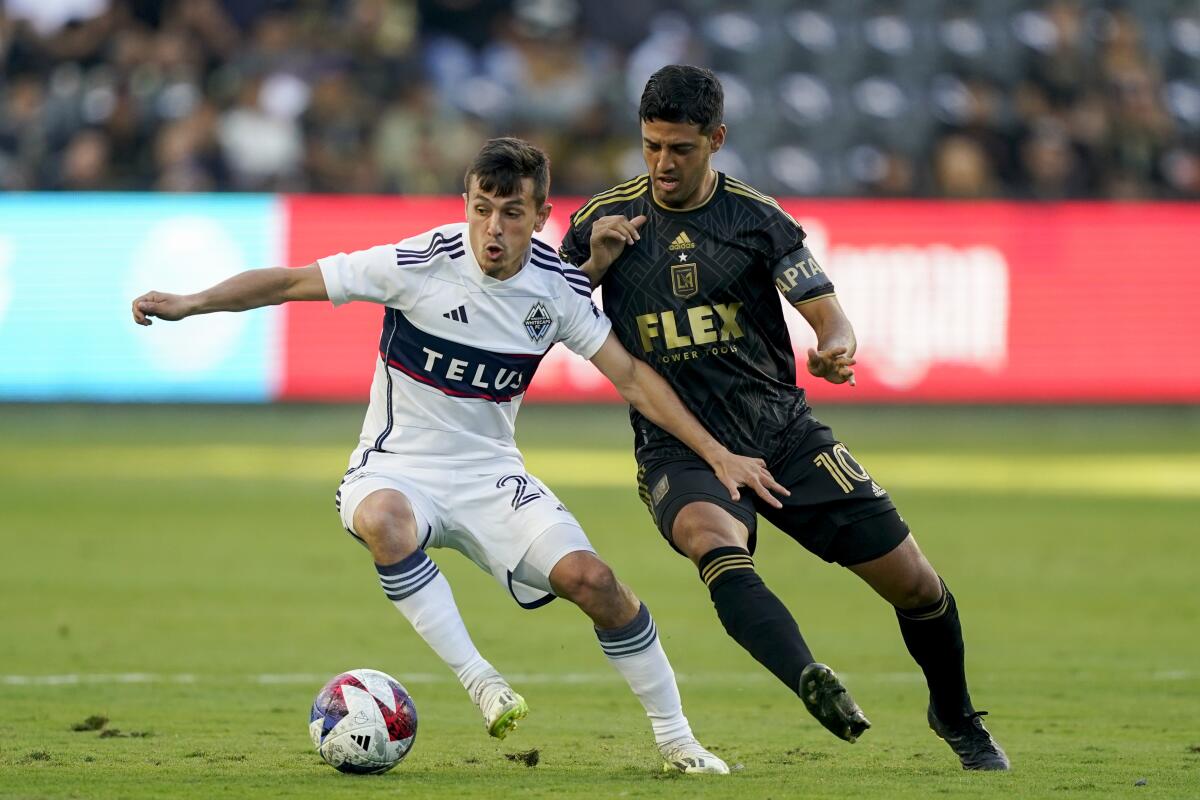 Vancouver Whitecaps midfielder Andrés Cubas and LAFC forward Carlos Vela vie for the ball.