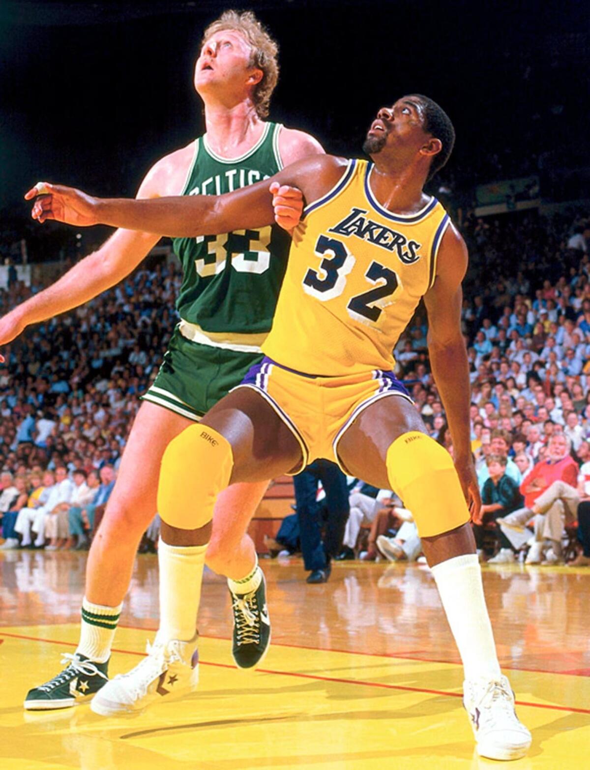 Magic Johnson battles for position against Larry Bird during a 1984 game at the Great Western Forum in Inglewood.