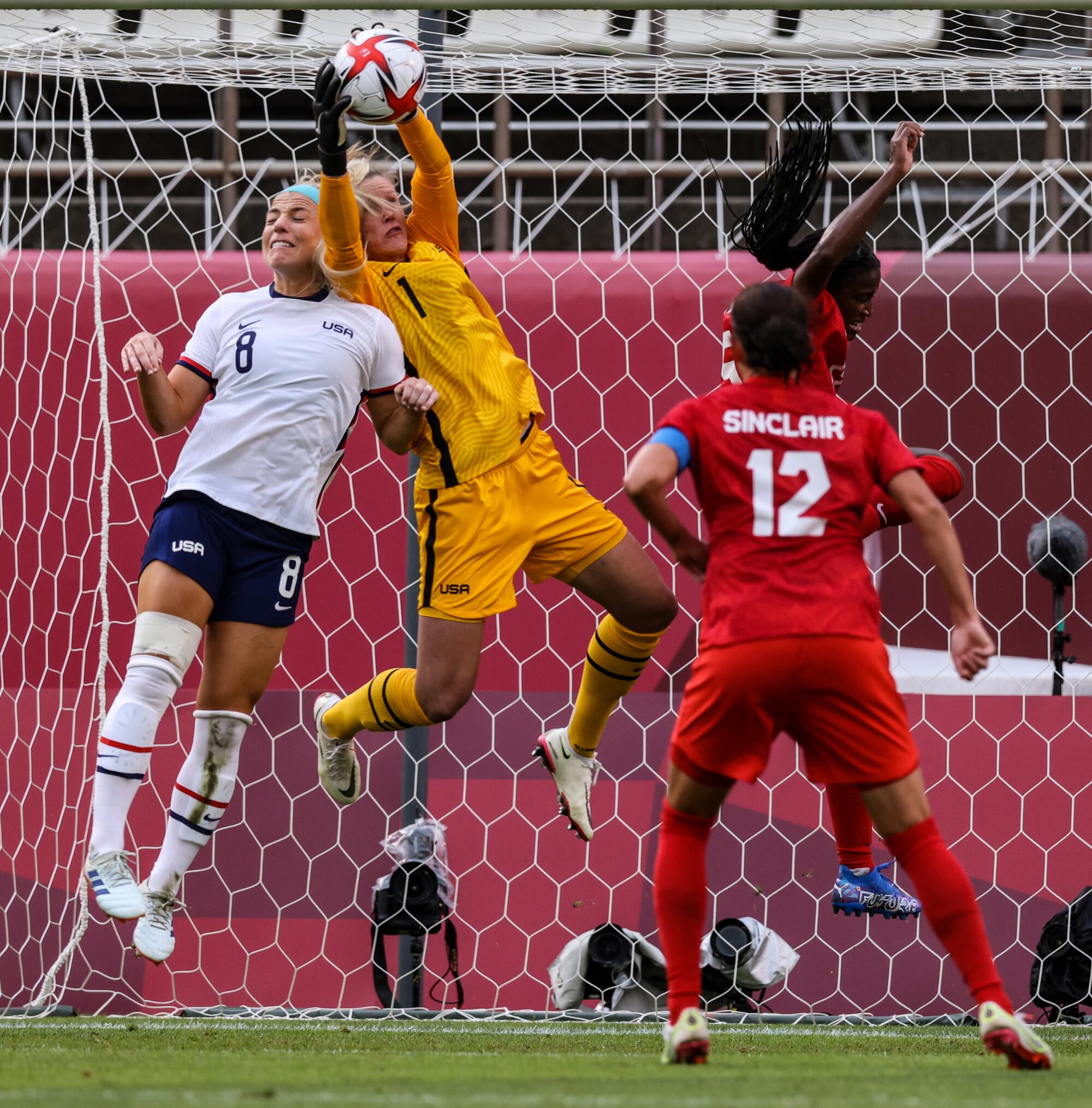 USA goalkeeper Alyssa Naeher collides with Julie Ertz as they prevent a goal during the semifinal in women's soccer.