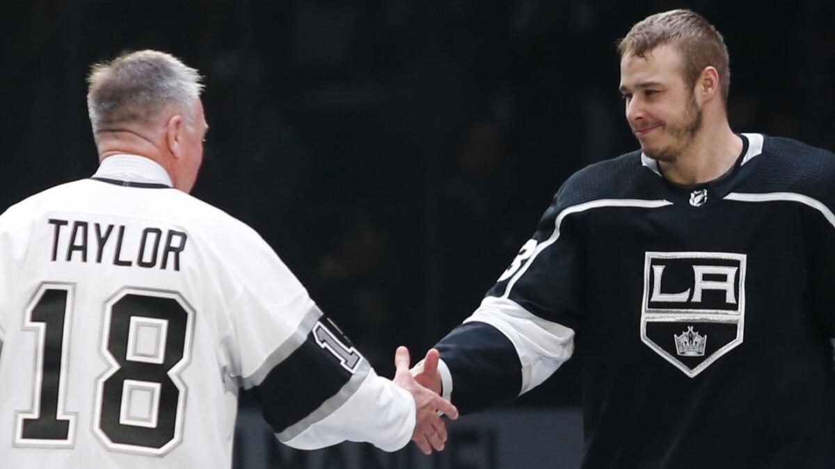 Kings forward Dustin Brown shakes hands with former King Dave Taylor during an April 1 ceremony at Staples Center honoring Brown as the team's all-time games-played leader.