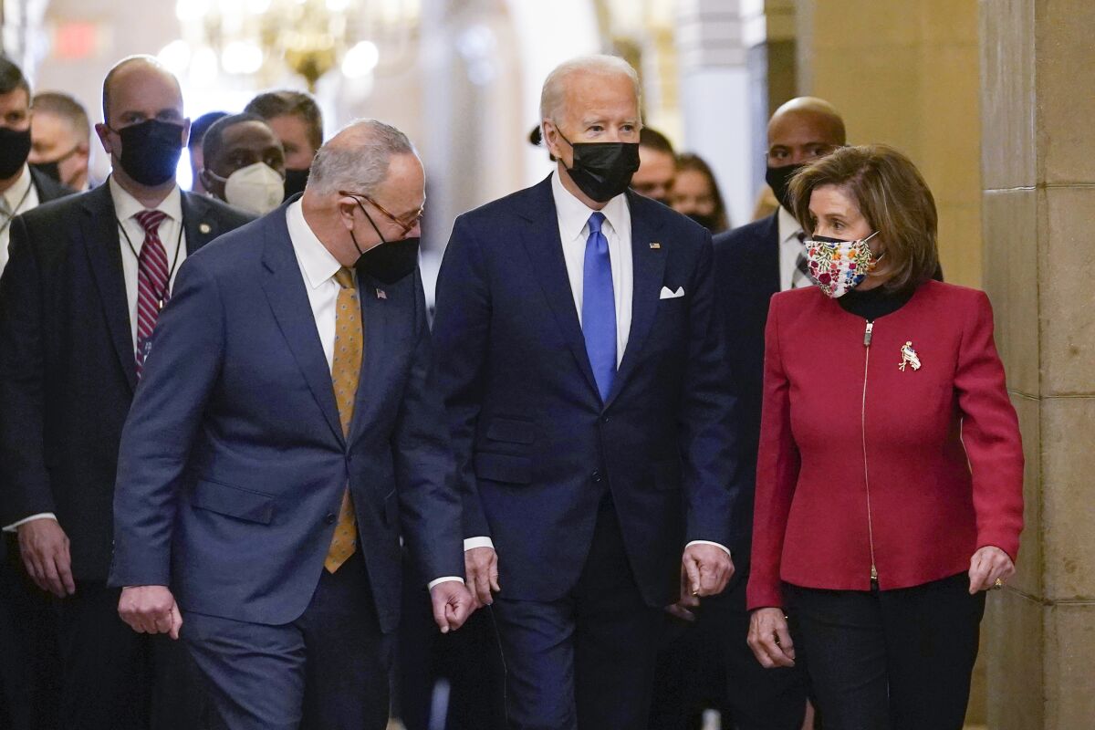 President Joe Biden is flanked by Senate Majority Leader Chuck Schumer of N.Y., left, and House Speaker Nancy Pelosi of Calif., right, after arriving on Capitol Hill in Washington, Thursday, Jan. 6, 2022, to speak at a ceremony marking the one year anniversary of the Jan. 6 attack on the Capitol by supporters loyal to then-President Donald Trump. (AP Photo/Susan Walsh)