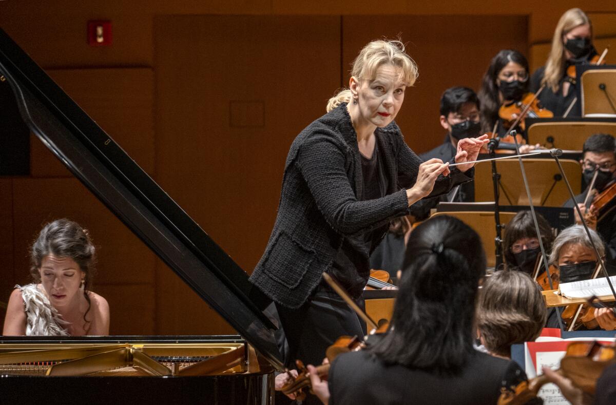 Conductor Susanna Mälkki, holding a baton, conducts the L.A. Philharmonic.
