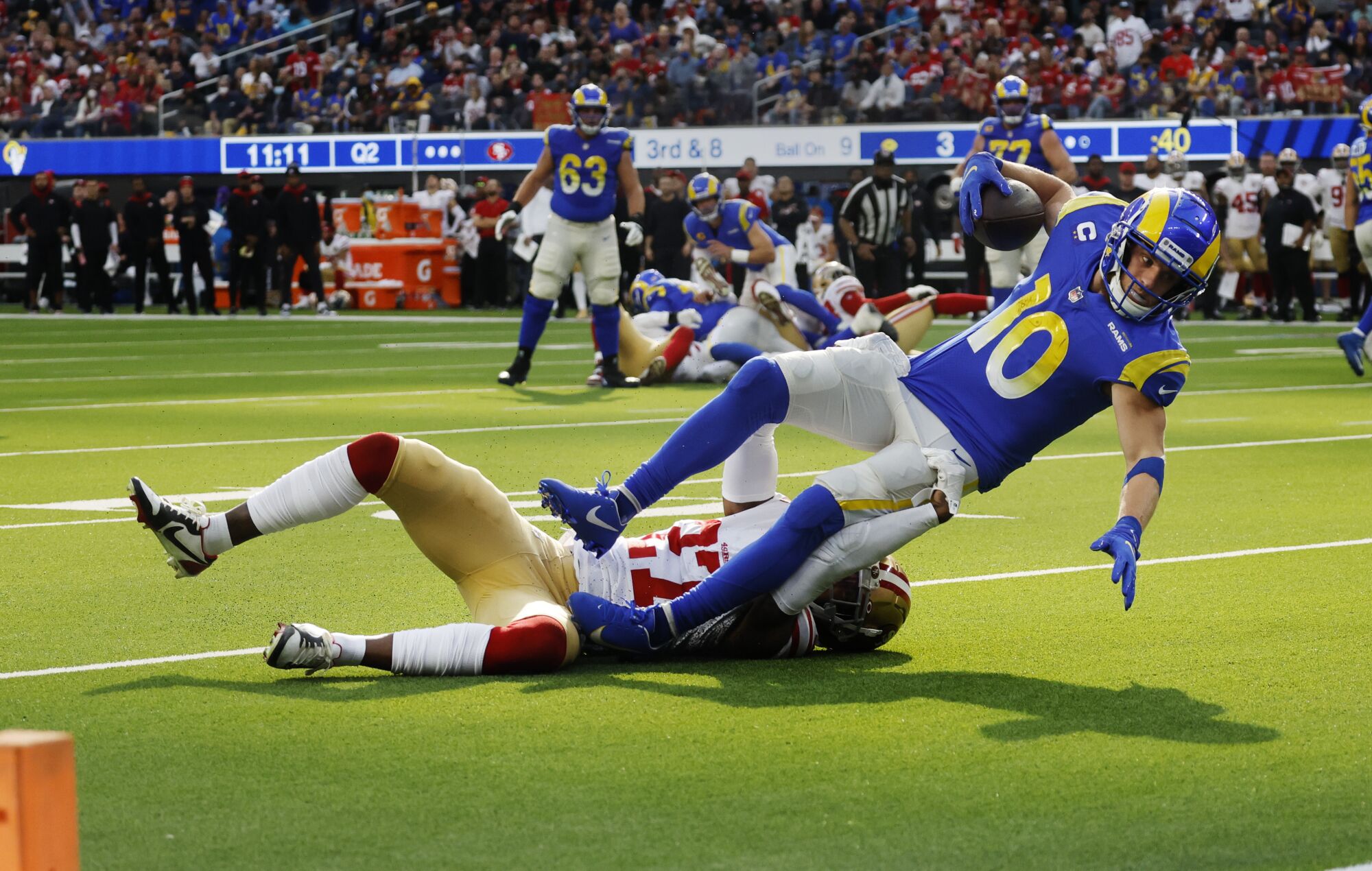 Rams receiver Cooper Kupp lurches for the end zone but comes up short while tackled by 49ers defensive back Dontae Johnson