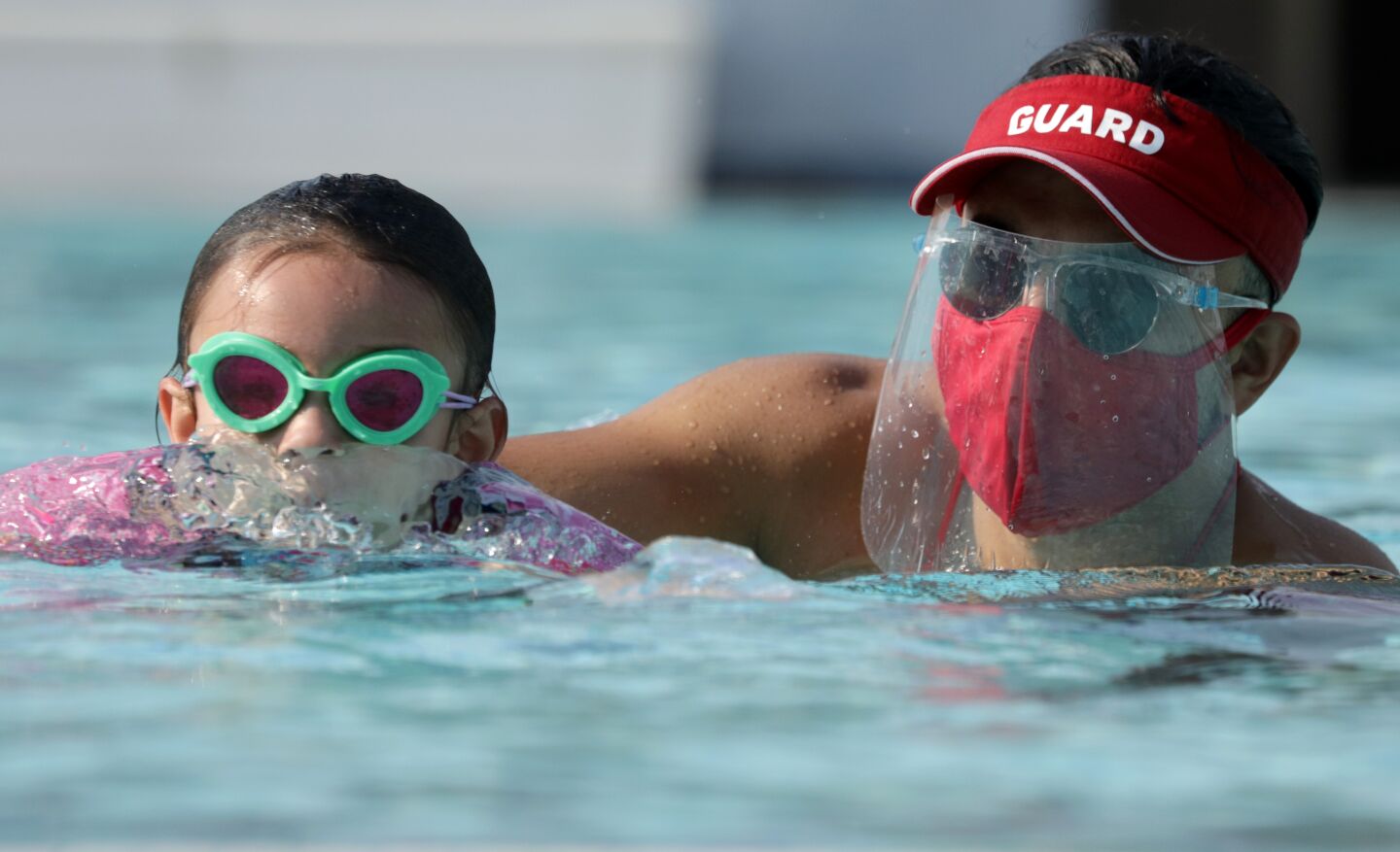 Lifeguard Michael Alfaro works with Kaila Holliday, 5, during a swim lesson in Palmdale.