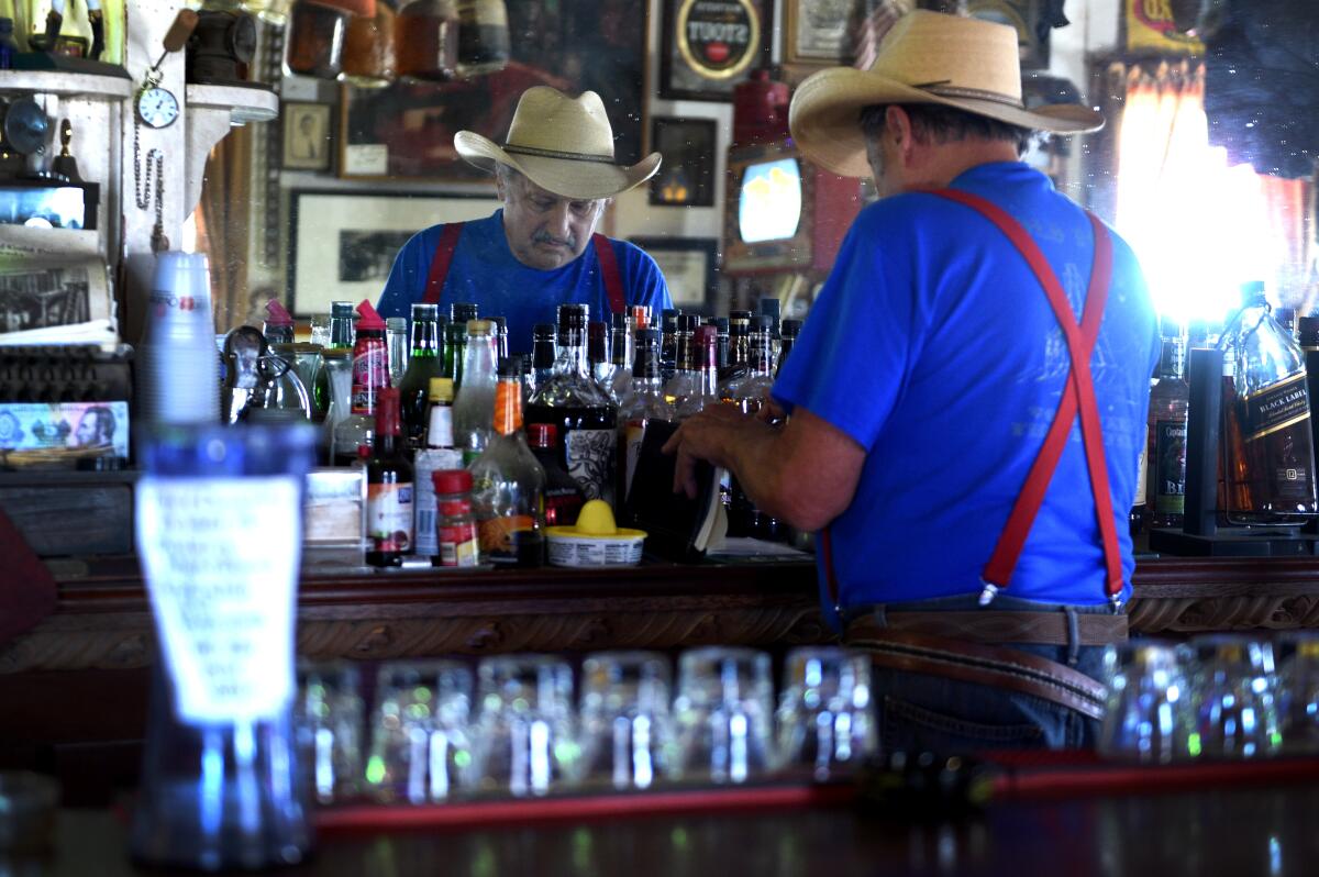 El propietario Walt Kremin atiende su bar en Gold Point, Nevada.
