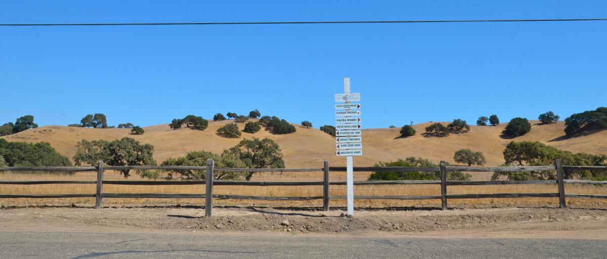 The hills are scattered with oaks along Ballard Canyon Road, just outside Los Olivos in Santa Barbara County wine country. As the sign in the foreground suggests, the area is full of vineyards, wineries and tasting rooms. Photo taken in 2012.
