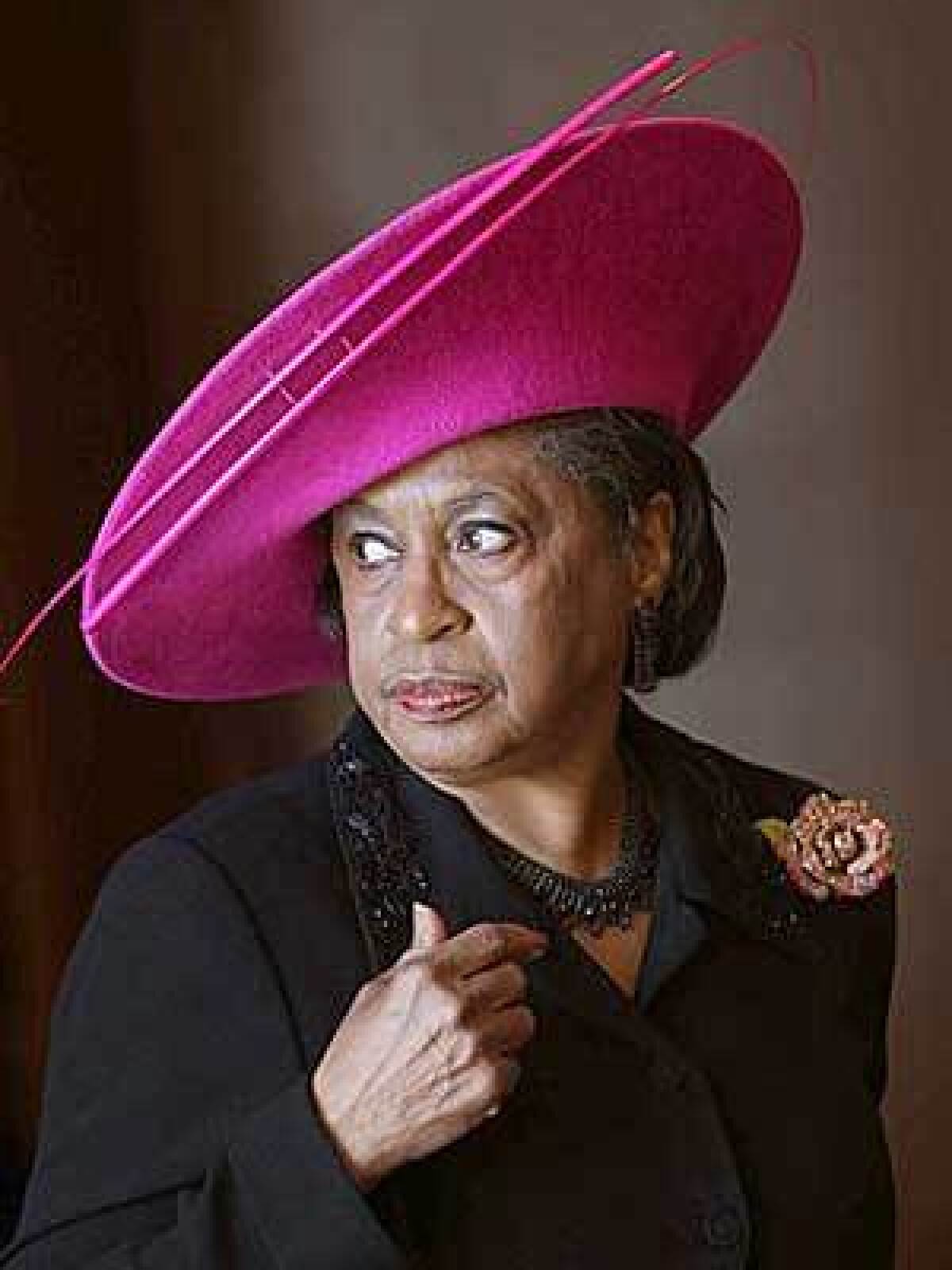 BETTY LOVELL: A dramatic fuchsia broad-brim topper.