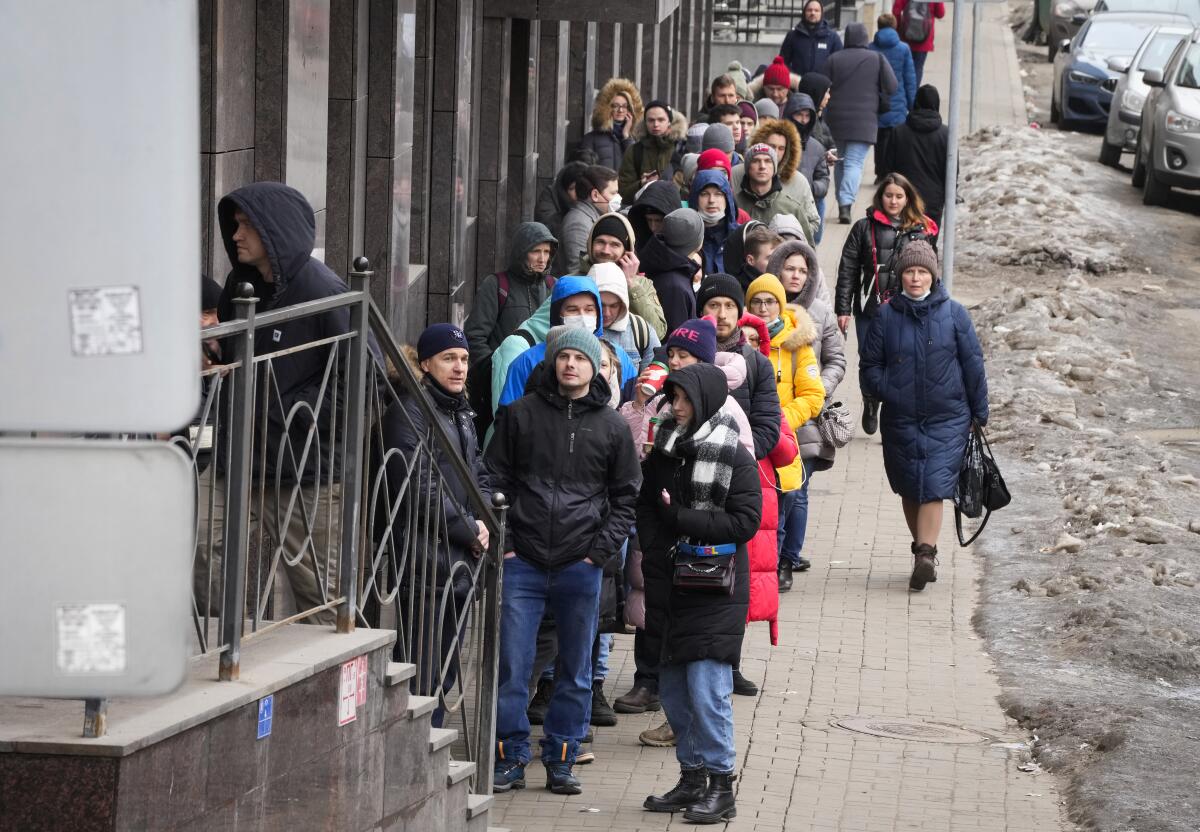 Un grupo de personas esperando para usar un cajero automático en San Petersburgo, Rusia.