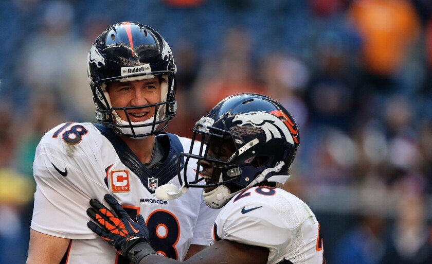 Denver quarterback Peyton Manning is congratulated by teammate Montee Ball, right, after breaking the NFL record for most touchdown passes in a season with 51 during the Broncos' 37-13 win over the Houston Texans on Sunday.