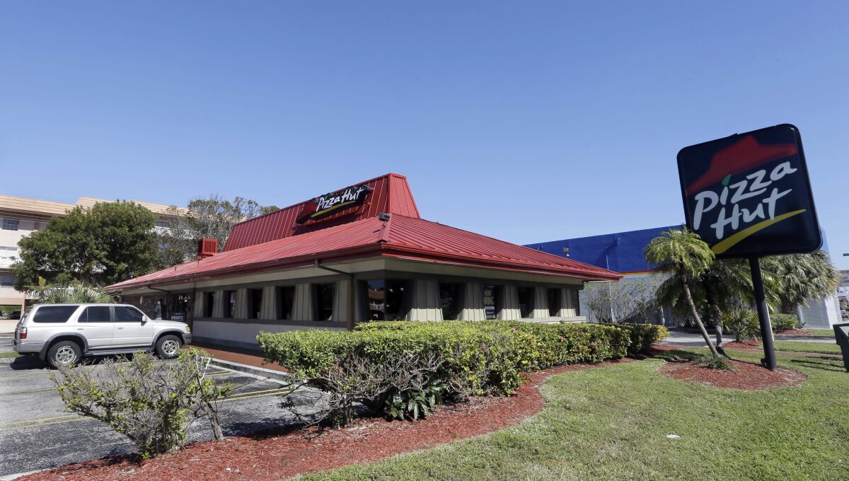 FILE- This Jan. 24, 2017, file photo shows a Pizza Hut in Miami. Pizza Hut has reached an agreement with one of its largest franchisees to close 300 underperforming U.S. restaurants. NPC International, a Leawood, Kansas-based franchisee, announced the agreement Monday, Aug. 17, 2020, in a bankruptcy court filing. (AP Photo/Alan Diaz, File)