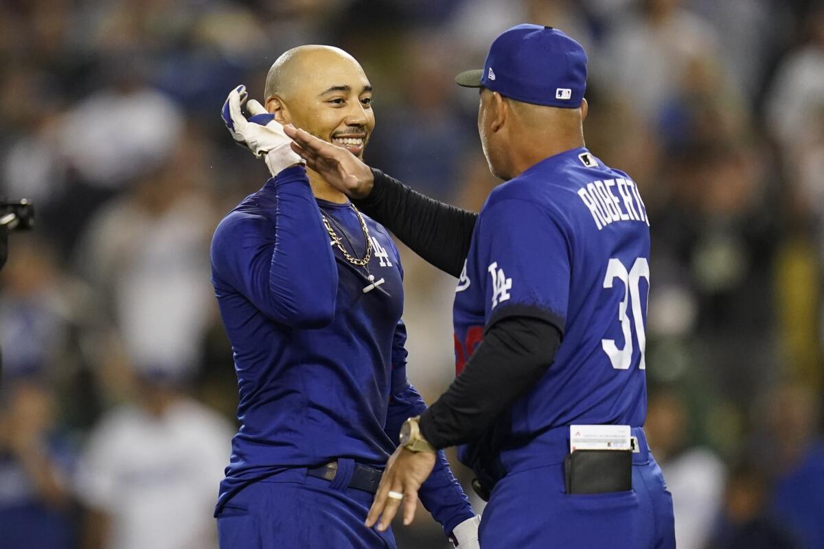 Dodgers' Mookie Betts is greeted manager Dave Roberts after he hit a walk-off single to win.