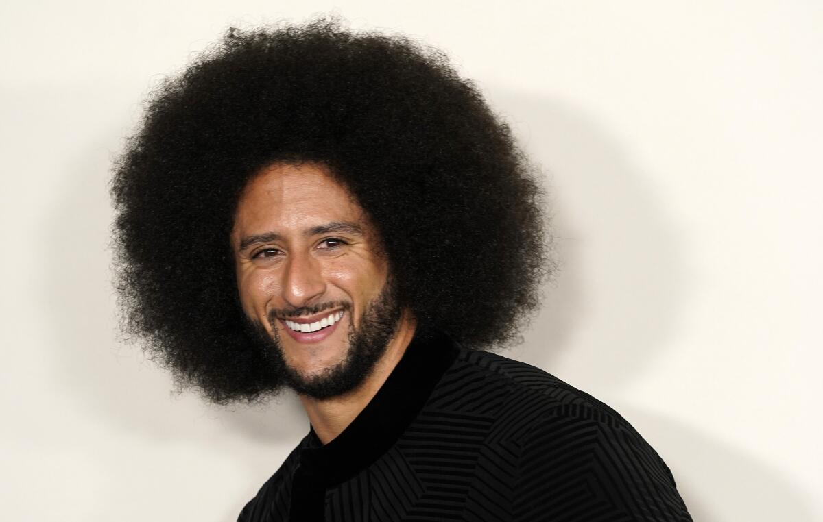 A smiling man who has a goatee and an afro.