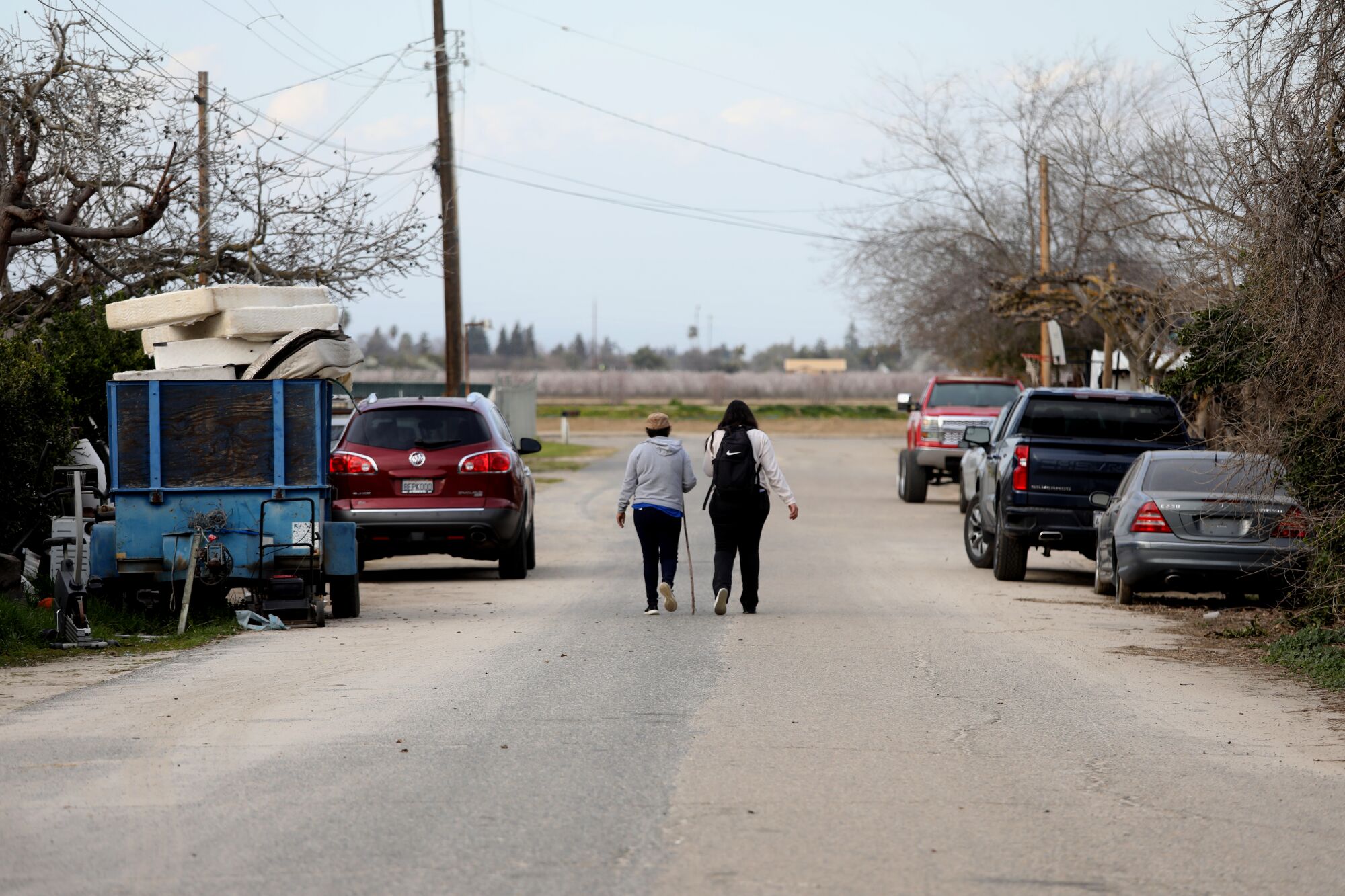 Residents walk on a road in the Tombstone neighborhood in Fresno County.