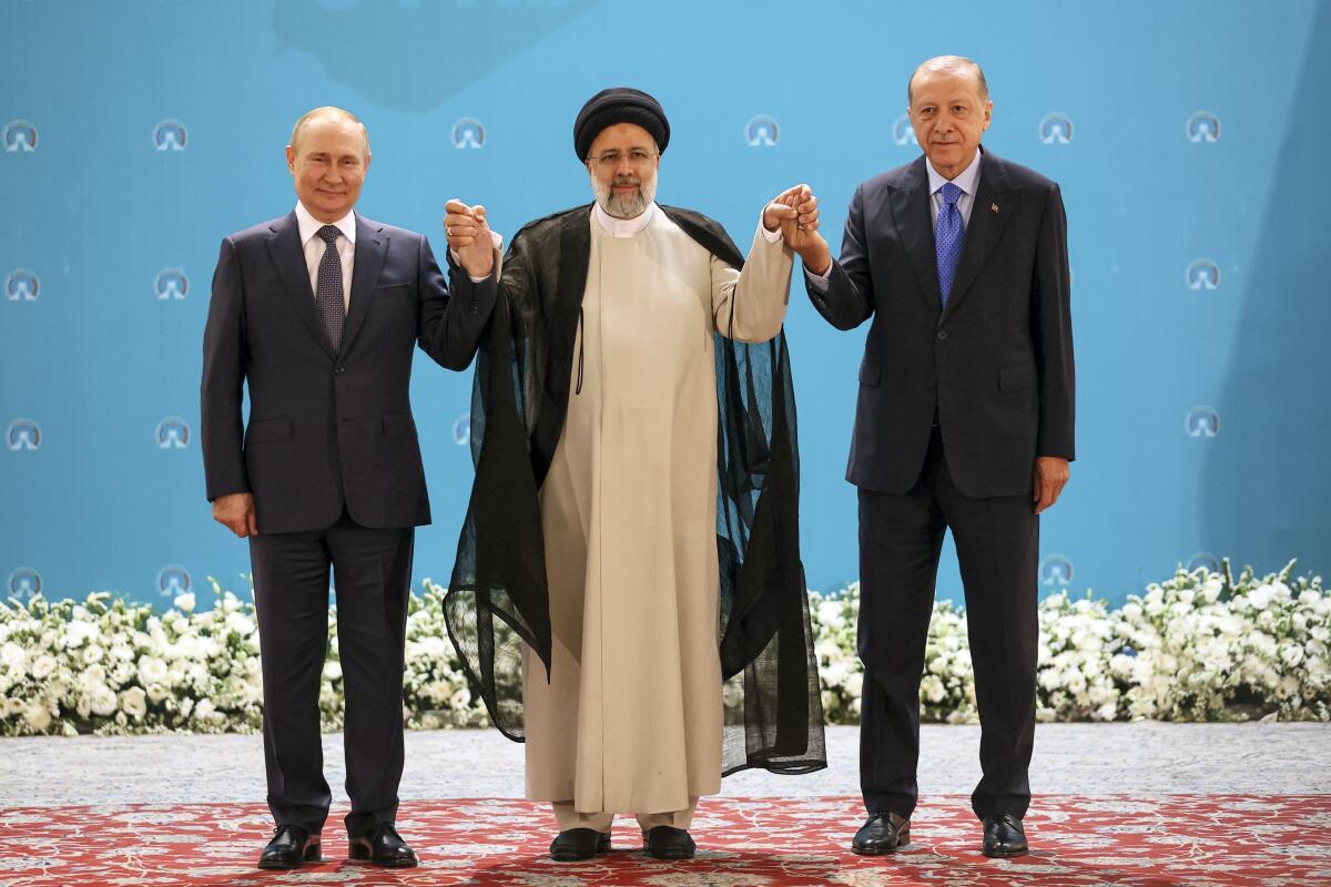 El presidente ruso Vladimir Putin, a la izquierda, el mandatario iraní Ebrahim Raisi, al centro, 
