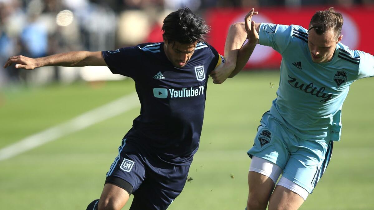 LAFC's Carlos Vela tries to drive past Seattle's Brad Smith during a match on April 21. Vela isn't part of Mexico's Gold Cup team.