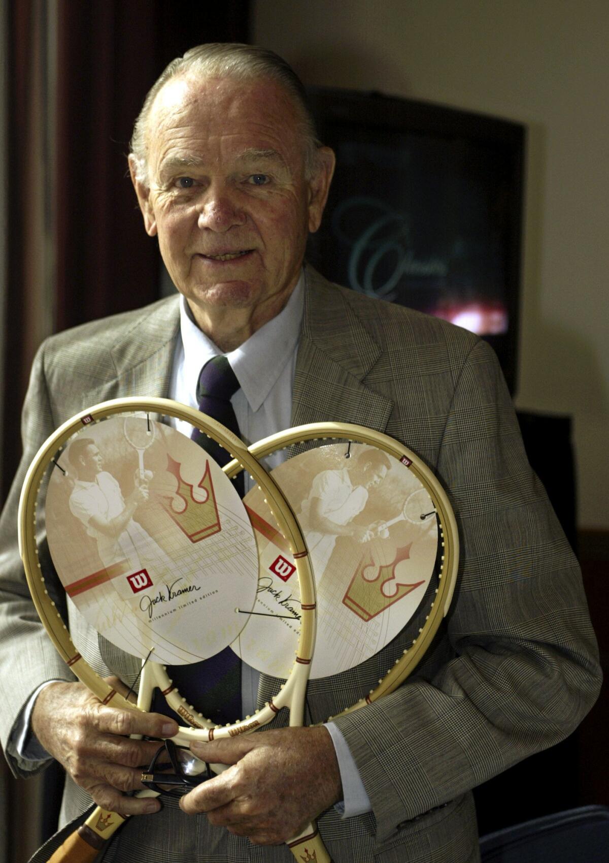 Jack Kramer holds a pair of his signature Wilson rackets in 2003. Kramer died in 2009 at the age of 88.