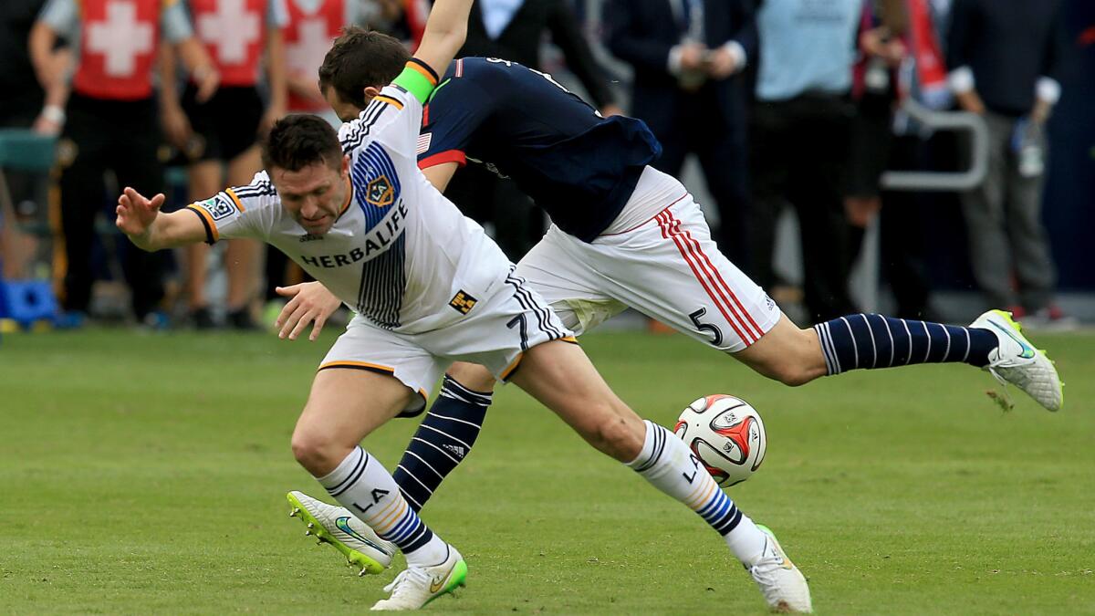 Galaxy forward Robbie Keane, left, is knocked down by New England Revolution defender A.J. Soares during the second half of the Galaxy's 2-1 win in the MLS Cup final Sunday.