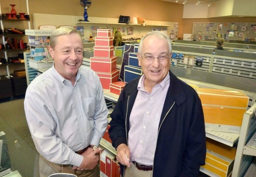 General Manager John Tackman, left, and Owner Colin West, of Newport Stationers, are all smiles after their landlord, the Irvine Co., agreed to a change their rent to something they could afford. The 41-year-old store had already announced they would close and started liquidating merchandise when clients complained, and the Irvine Co. lowered the rent.