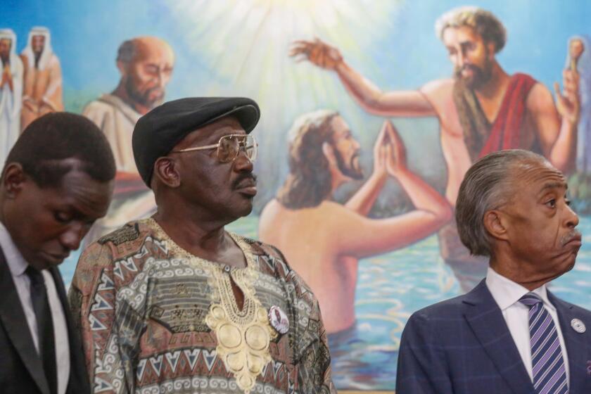 From left: Alfred Olango's twin brother, Apollo, and father, Richard, join the Rev. Al Sharpton at a news conference in South Los Angeles.