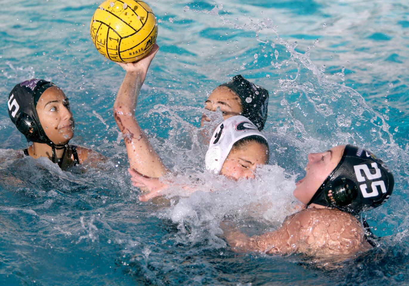 Glendale High School's water polo player #9 Lori Berberian manages to get a shot off even though triple-teamed by Hoover High School in game at HHS in Glendale on Tuesday, January 12, 2016. Glendale won 16-7.