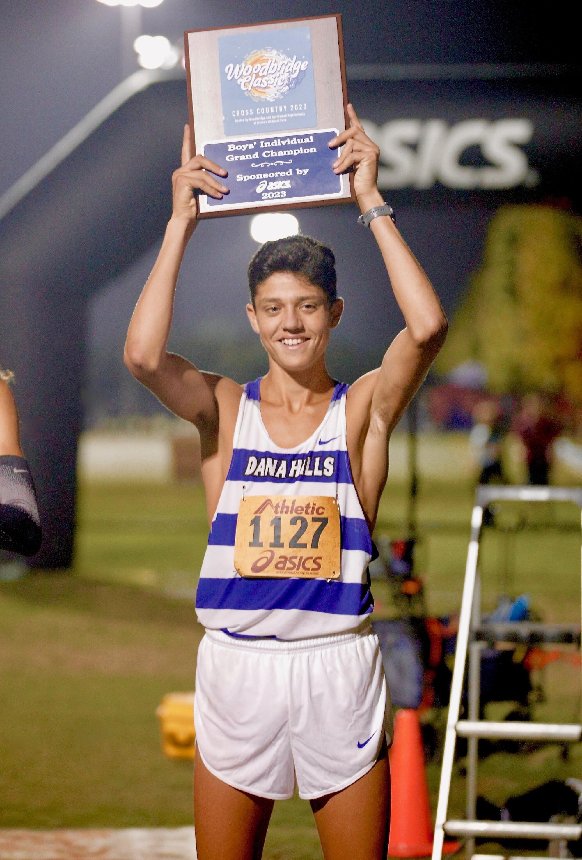 Dana Hills' Evan Noonan holds aloft the first-place plaque after winning the boys' sweepstakes race at Woodbridge Classic.