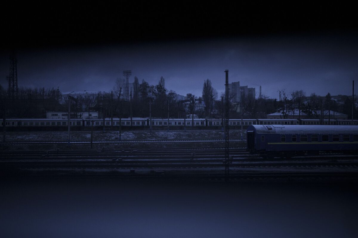 Trains are seen through a small gap in the shades of a train arriving in Kyiv, Ukraine, on Tuesday, March 8, 2022. (AP Photo/Felipe Dana)