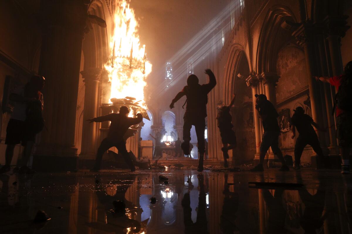 The statue of a saint is engulfed as the San Francisco de Borja church in Santiago, Chile, burns on Oct. 18. 
