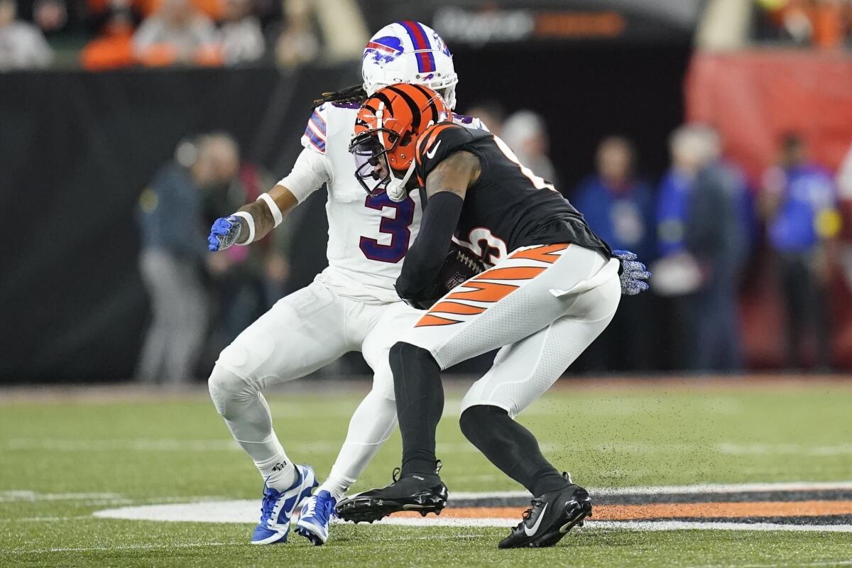 El wide receiver de los Bengals de Cincinnati Tee Higgins lleva el balón ante el safety de los Bills de Buffalo 