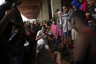 Cargadores de mercancía cierran los puños y amenazan con iniciar una pelea después de que sus carretas chocaron accidentalmente en el mercado mayorista de Cease, el jueves 29 de septiembre de 2022, en Río de Janeiro. (AP Foto/Matias Delacroix)
