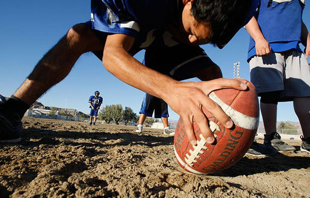 The Trona High School 8-man football squad practices before the home opener on the school's dirt field. Football in the dirt is a tradition at Trona and a point of pride.