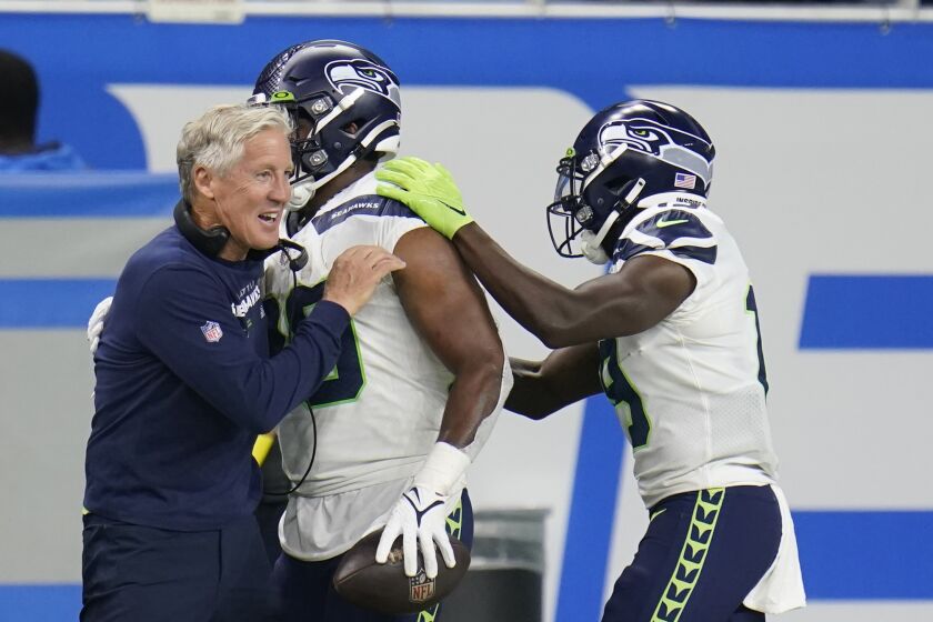 Seattle Seahawks head coach Pete Carroll hugs running back Rashaad Penny after Penny's touchdown during the second half of an NFL football game against the Detroit Lions, Sunday, Oct. 2, 2022, in Detroit. (AP Photo/Paul Sancya)