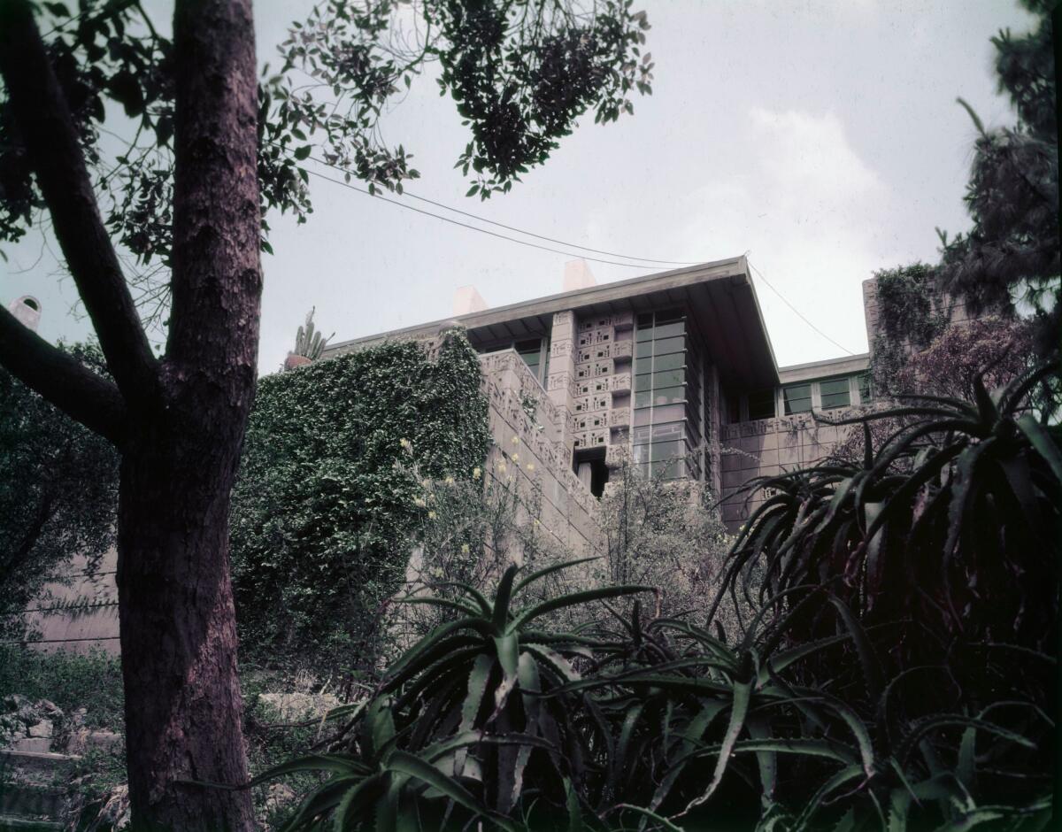 A vintage color image from the 1950s shows an upward view of the textile block exterior of the Freeman House.