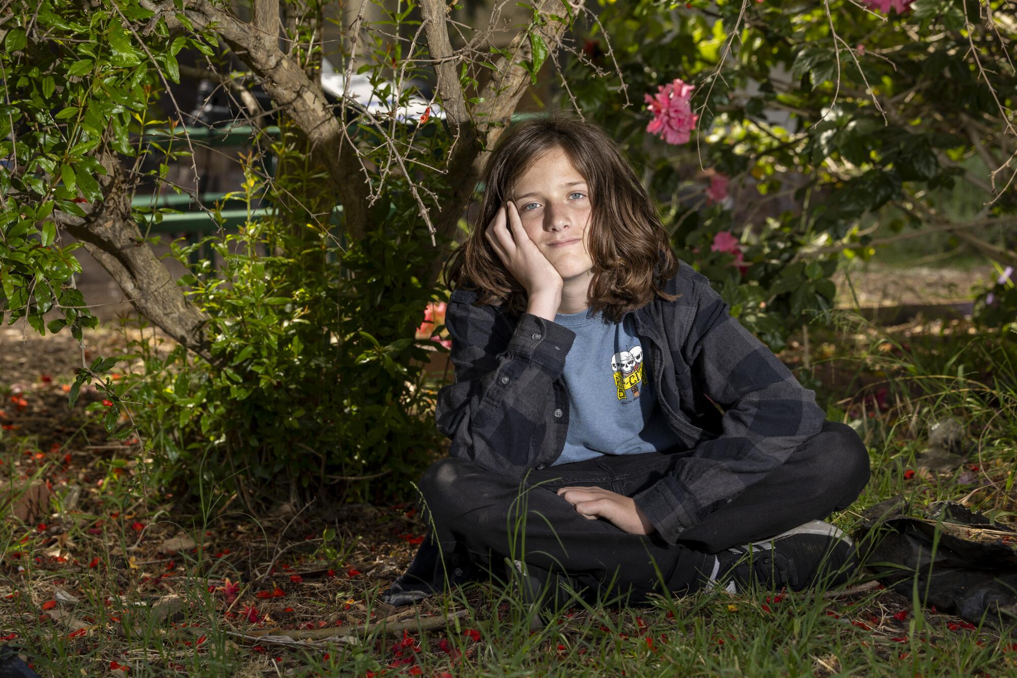 Declan McAdams sits cross-legged with chin on one hand.