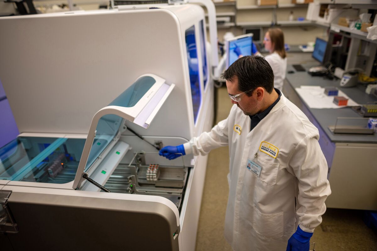 Marcelo Prado, clinical lab scientist and supervisor of the molecular lab, and Katie Zegarski, supervising clinical lab scientist, with the Department of Pathology and Laboratory Medicine at UC Davis Health in Sacramento, demonstrate how to load samples into the Roche Diagnostics cobas 6800 instrument. The instrument, one of the few of its kind at a west coast academic medical center, is undergoing validation this week before UC Davis Health begins to test for the COVID-19 strand of coronavirus. The instrument is capable of testing nearly 1,500 samples in 24 hours, with quick results.