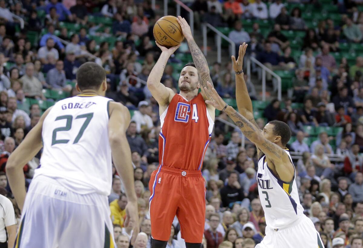 Clippers guard J.J. Redick (4) shoots as Utah Jazz's George Hill (3) and Rudy Gobert (27) defend in the second quarter.