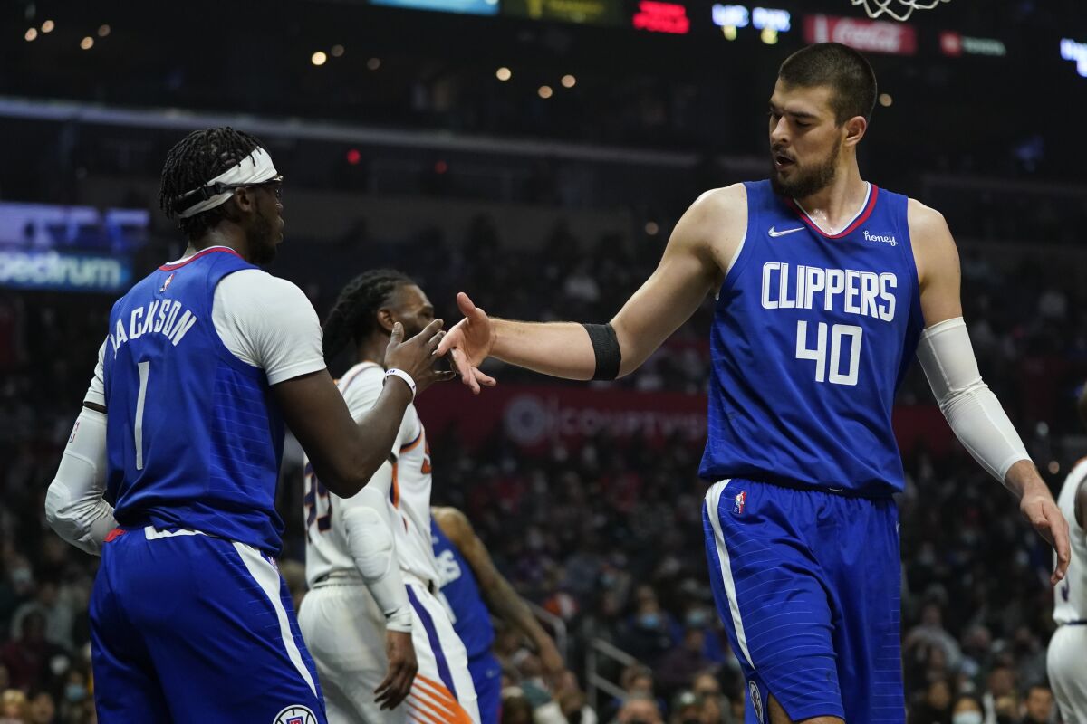 Los Angeles Clippers guard Reggie Jackson (1) and center Ivica Zubac (40) celebrate after a score during the first half of an NBA basketball game against the Phoenix Suns in Los Angeles, Monday, Dec. 13, 2021. (AP Photo/Ashley Landis)
