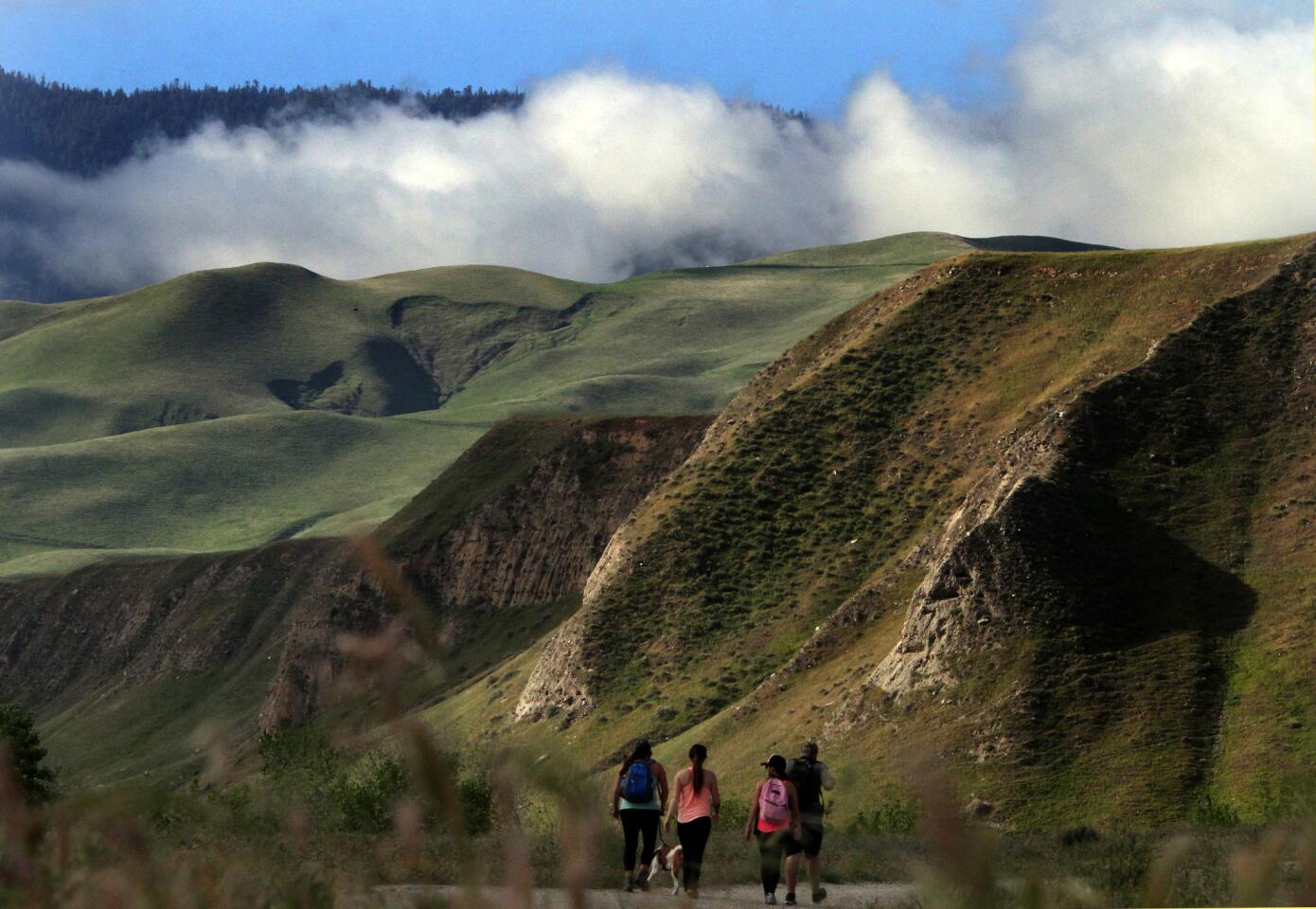 Morning hikers watch clouds drift along the ridgeline as they make their way up Emigdio Canyon.