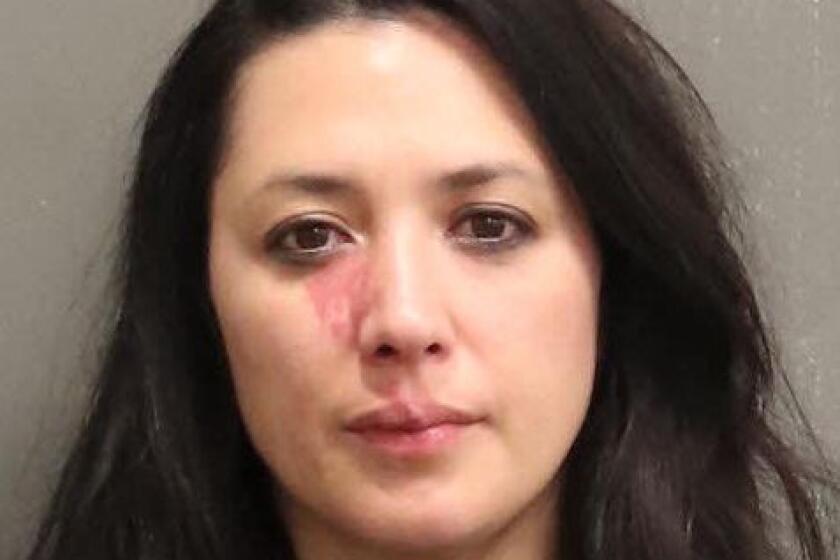 A mug shot of a woman with long hair showing a bruise below her right eye