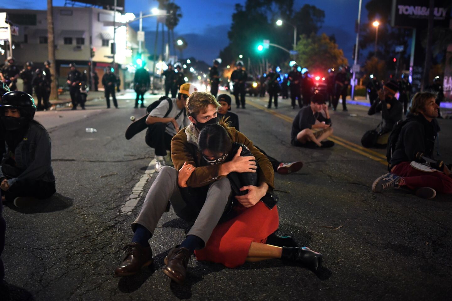 A couple of protesters embrace on Fairfax Avenue in Los Angeles Saturday.
